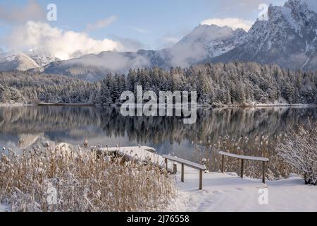 Der Lautersee oberhalb von Mittenwald im Neuschnee eines schönen Wintertages mit Steg, im Hintergrund das Westkarwendel Stockfoto