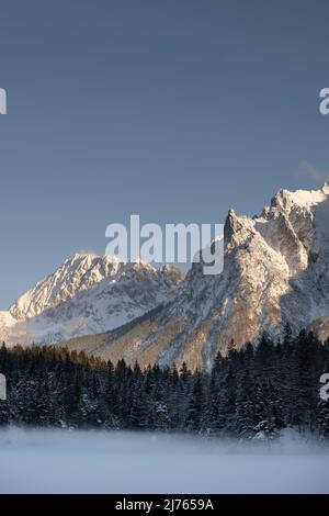 Der gefrorene lautersee mit Bodennebel und Schnee im Winter. Im Hintergrund das Karwendelgebirge mit der Viererspitze und dem Wörner Stockfoto