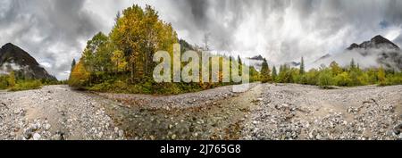 Ein Panorama des Rissbaches im sogenannten eng im engen Tal. Im Hintergrund Nebel, Wolken und die beeindruckende Lalidererwande, sowie das Gamsjoch, im Vordergrund der Strom und bunte Herbstblätter. Stockfoto