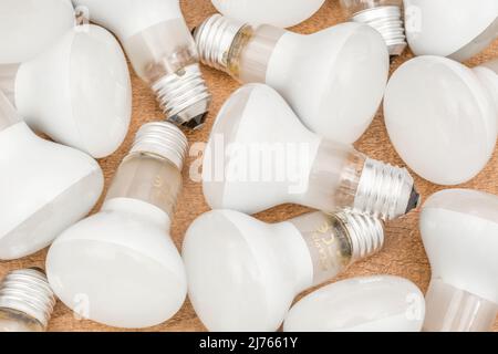 Mehrere E27 Edison Screw Glühlampen mit Glasreflektor auf einer Tischplatte. Für Beleuchtung, britische Beleuchtungsindustrie, Beleuchtung abstrakt. Stockfoto