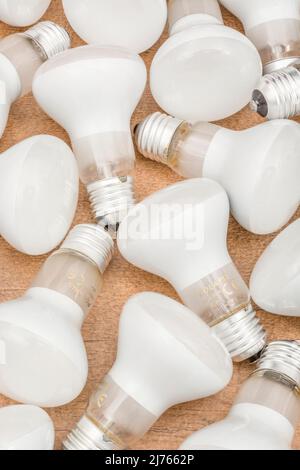 Mehrere E27 Edison Screw Glühlampen mit Glasreflektor auf einer Tischplatte. Für Beleuchtung, britische Beleuchtungsindustrie, Beleuchtung abstrakt. Stockfoto