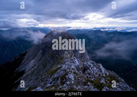 Der zweite Gipfel des Guffert in den Brandenberger Alpen in Tirol bei mäßigem bis schlechtem Wetter. Starker Wind und düsteres Licht liegen über dem Grat ohne offiziellen Wanderweg Stockfoto