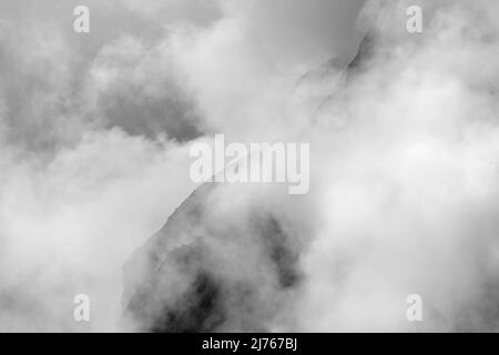 Felsen hängen im Nebel. Die Ränder und Flanken des Gamsjochs im Karwendel über dem großen Ahornboden im Engstal in Tirol. Harte Bergschemata in den Bergen der Alpen in schwarz-weiß Stockfoto