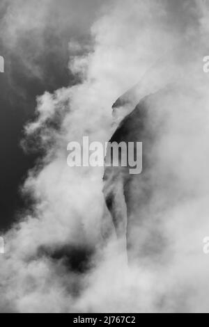 Felsen hängen im Nebel. Die Ränder und Flanken des Gamsjochs im Karwendel über dem großen Ahornboden im Engstal in Tirol. Harte Bergschemata in den Bergen der Alpen in schwarz-weiß Stockfoto