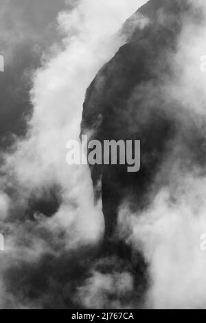 Felsen hängen im Nebel. Die Ränder und Flanken des Gamsjochs im Karwendel über dem großen Ahornboden im Engstal in Tirol. Harte Bergschemata in den Bergen der Alpen in schwarz-weiß Stockfoto