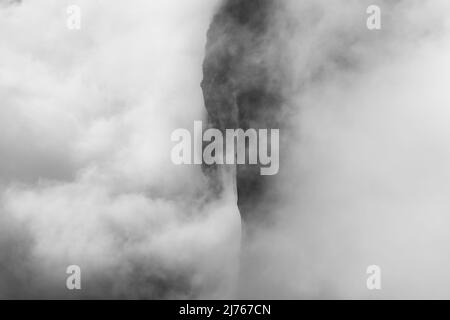 Felsen hängen im Nebel. Die Ränder und Flanken des Gamsjochs im Karwendel über dem großen Ahornboden im Engstal in Tirol. Harte Bergschemata in den Bergen der Alpen in schwarz-weiß Stockfoto