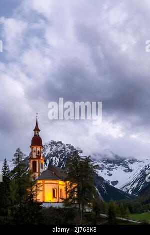 Die beleuchtete Nikolaikirche am Brenner in Obernberg bei Innsbruck in Tirol. Stockfoto