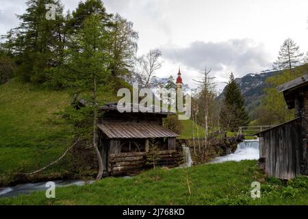 Zwei alte Mühlen am Bach bei der Nikolaikirche in Obernberg/Tirol beim Brenner. Stockfoto