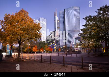 Deutschland, Hessen, Rhein-Main-Gebiet, Frankfurt am Main, Wolkenkratzer in der Taunusanlage, Bankenviertel, Euro-Skulptur vor dem Eurotower zur blauen Stunde im Herbst Stockfoto