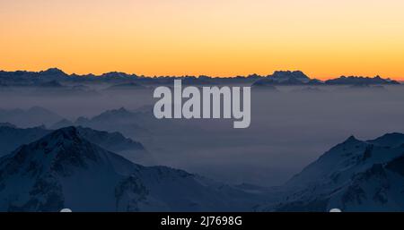 Berge und Dunst an einem kalten Winterabend. Blick über Vorarlberg auf die Schweizer Berge mit Glarus, Uri und Berner Alpen. Österreich, Schweiz, Europa Stockfoto