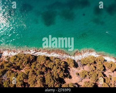 Von oben können Sie das Meer und einen Teil des Gebiets von Seget Vranjica in Kroatien sehen. Im Vordergrund viel Wald. Stockfoto