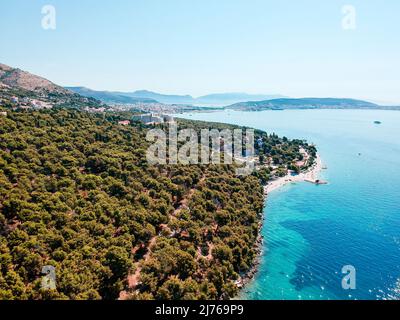 Von oben können Sie das Meer und einen Teil des Gebiets von Seget Vranjica in Kroatien sehen. Im Vordergrund viel Wald. Stockfoto