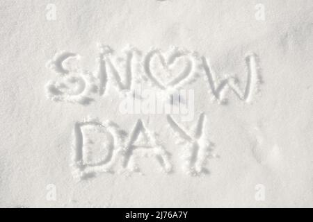 Text 'Snow day' geschrieben im Schnee, mit einem Herz für Buchstabe o; Konzept eines glücklichen Tages wegen des verschneiten Wetters Stockfoto