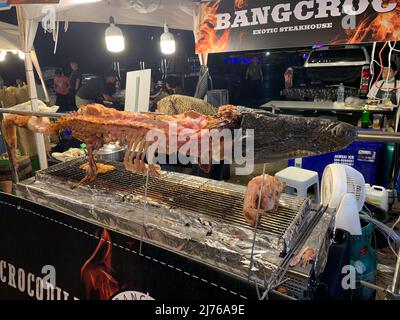 Crocodile auf dem Grill, Verkauf von Krokodilfleisch, Asiatique am Flussufer, Unterhaltungsmeile, Nachtmarkt, Chao Praya River, Bangkok, Thailand, Asien Stockfoto