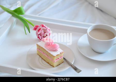 Muttertag, Liebe für Mutter. Morgen mit Sorge für Mama. Ein Tablett mit Kaffee und Kuchen auf dem Bett. Postkarte geschrieben von einem Kind Tochter oder Sohn Ich liebe Mutter PR Stockfoto