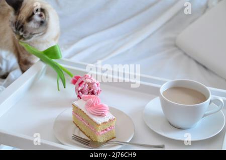 Muttertag, Liebe für Mutter. Morgen mit Sorge für Mama. Ein Tablett mit Kaffee und Kuchen auf dem Bett. Postkarte geschrieben von einem Kind Tochter oder Sohn Ich liebe Mutter PR Stockfoto