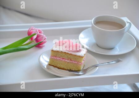 Muttertag, Liebe für Mutter. Morgen mit Sorge für Mama. Ein Tablett mit Kaffee und Kuchen auf dem Bett. Postkarte geschrieben von einem Kind Tochter oder Sohn Ich liebe Mutter PR Stockfoto