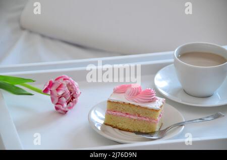 Muttertag, Liebe für Mutter. Morgen mit Sorge für Mama. Ein Tablett mit Kaffee und Kuchen auf dem Bett. Postkarte geschrieben von einem Kind Tochter oder Sohn Ich liebe Mutter PR Stockfoto