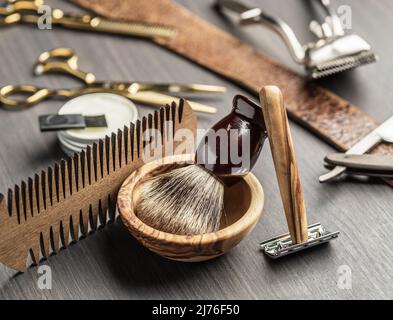 Klassische Grooming- und Frisierwerkzeuge auf Holzhintergrund. Draufsicht auf Barbershop-Instrumente, die auf dunklem Holztisch liegen. Stockfoto