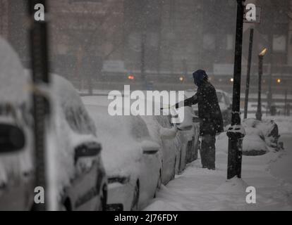 NEW YORK, N.Y. – 1. Februar 2021: Eine Person entfernt während eines Wintersturms Schnee von einem Fahrzeug im Battery Park City. Stockfoto