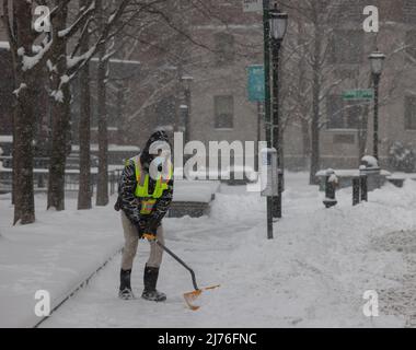 NEW YORK, NY – 1. Februar 2021: Während eines Wintersturms schaufelt eine Person Schnee von einem Bürgersteig in Lower Manhattan. Stockfoto