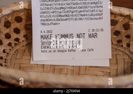 Die Worte - MAKE HUMMUS NOT WAR - stehen auf einer Quittung im Kafka Hummus Café in Prag. Stockfoto