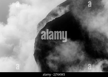 Felsen hängen im Nebel. Die Ränder und Flanken des Gamsjochs im Karwendel über dem großen Ahornboden im Engstal in Tirol. Harte Bergschemata in den Bergen der Alpen in schwarz-weiß Stockfoto