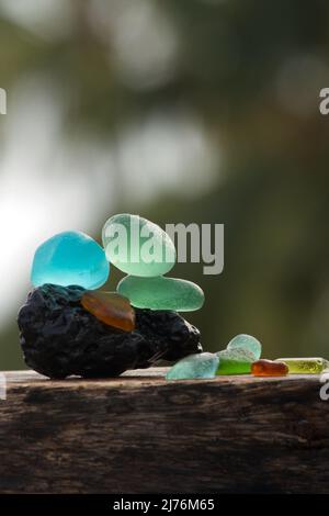 Nahaufnahme von Seeglassteinen und Balancen auf einem Lavastein Stockfoto