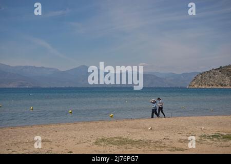 Besucher des Strandes von Carathona in der Nähe der historischen Stadt Nafplio auf dem Peloponnes, Griechenland, Europa Stockfoto