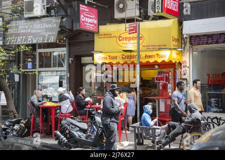 Menschen essen und spazieren auf der MacDougal Street im Herzen von Greenwich Village, New York City. Stockfoto