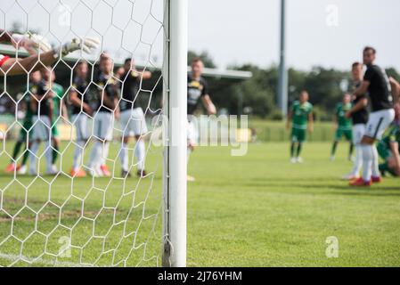 Details zum Beitrag des Tores mit den Netto- und Fußballspielern während des Freistocks im Hintergrund. Stockfoto