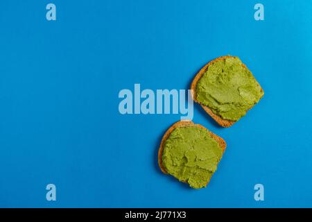 Toast mit Guacamole isoliert auf blauem Hintergrund Bruschetta mit Avocado. Gesundes Frühstück. Superfood. Stockfoto