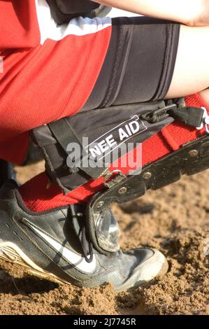 Kniehilfen für junge Mädchen, Baseballspieler und Softballfänger zum Schutz des Knies, wenn sie lange Zeit hinter dem Teig hocken Stockfoto