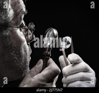 Großer Edelstein in der Hand eines Juweliers aus nächster Nähe. GEM-Prozess zur Identifizierung und Bewertung. Stockfoto