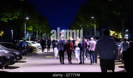 06. Mai 2022, Niedersachsen, Hannover: Im Expo Park laufen Interessierte zwischen getunten Fahrzeugen. Am Freitagabend trafen sich wieder Hunderte von Autotunern und Autoenthusiasten auf dem ehemaligen Expo-Gelände in Hannover. Die Polizei von Hannover kontrollierte zahlreiche Fahrzeuge auf den Zufahrtsstraßen. Foto: Julian Stratenschulte/dpa Stockfoto