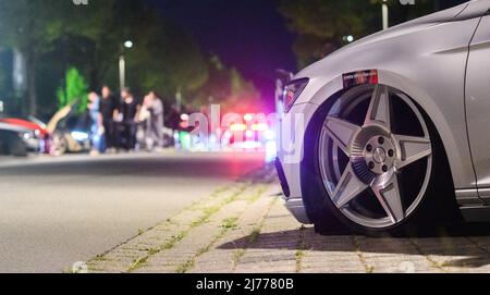 06. Mai 2022, Niedersachsen, Hannover: Im Expo Park laufen Interessierte zwischen getunten Fahrzeugen. Am Freitagabend trafen sich wieder Hunderte von Autotunern und Autoenthusiasten auf dem ehemaligen Expo-Gelände in Hannover. Die Polizei von Hannover kontrollierte zahlreiche Fahrzeuge auf den Zufahrtsstraßen. Foto: Julian Stratenschulte/dpa Stockfoto