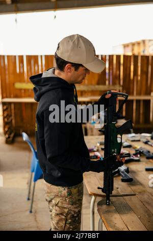 Airsoft Soldat, der sich auf den Kampf am Trainingsgelände vorbereitet Stockfoto