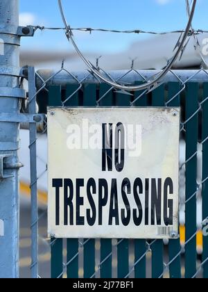 Kein Trespassing-Schild am Zaun mit Stacheldraht Stockfoto