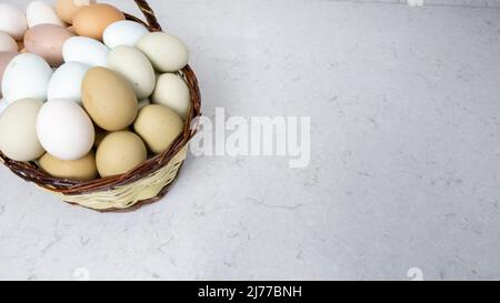 Freilandeier in verschiedenen Farben befinden sich in einem Korb. Stockfoto