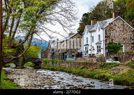 Riverside Cottages und historische alte Steinbrücke in Beddgelert, Snodonia, Gwynedd, Nordwales Stockfoto