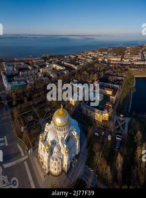 Luftaufnahme der Meereshauptstadt Russlands Kronstadt bei Sonnenuntergang, die goldene Kuppel der riesigen Hauptkathedrale von St. Nikolaus, der Seehafen mit Stockfoto