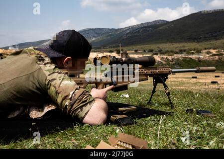 Ein US Navy SEAL Sniper von Naval Special Warfare Group 2 schaut sich den Umfang seines Gewehr im griechischen Z’ Moira Amfivion Katadromon (ZMAK) Special Forces Training Center an, um sich auf die Übung Orion in den Bergen Griechenlands vorzubereiten, 29. März 2022. Übung Orion stärkt Griechenland als Leiter der regionalen Special Operations Forces, verbessert die Interoperabilität über mehrere Bereiche hinweg und stärkt die Beziehungen zu NATO- und nicht-NATO-Partnern. Die Übung konzentriert sich auf die Hervorhebung operativer Fähigkeiten, internationaler Kooperationen und konventioneller und hybrider Kampfschulungen. (USA Armee-ph Stockfoto