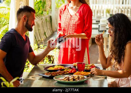 indischer Mann, der im Restaurant per Kreditkarte-App auf dem Smartphone-Reader bezahlt Stockfoto