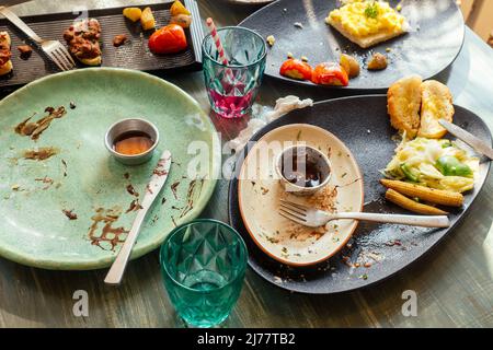 Schmutzige Teller und Glas auf dem Tisch im Café Stockfoto