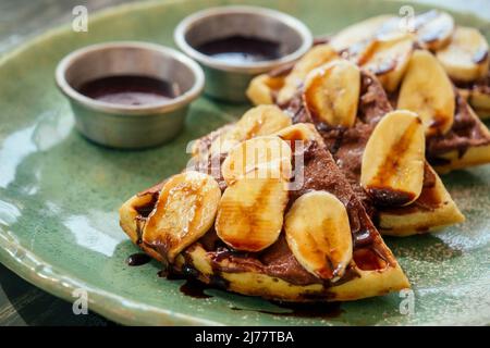 Belgische Waffeln mit Bananen- und Schokoladenüberzug Stockfoto