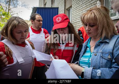 Velievaa (22) und ihre Kollegen helfen einer Frau, ein Antragsformular für Medikamente auszufüllen, die sie in Charkiw benötigte. Trotz des ständigen Beschusses von russischen Truppen, die die Stadt Charkow umzingeln, setzten Mediziner und Freiwillige des Roten Kreuzes ihre Arbeit 24/7 fort, um Leben zu retten und Menschen in Not zu helfen. (Foto von Alex Chan Tsz Yuk / SOPA Images/Sipa USA) Stockfoto