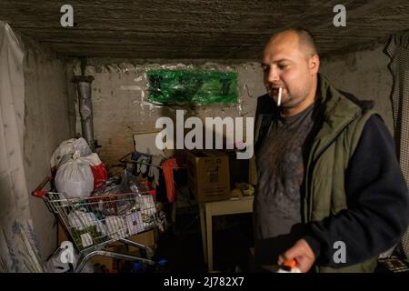 28. April 2022, Kharkiv, Kharkiv'ka Oblast'', Ukraine: Ein Mann raucht eine Zigarette in einem Bombenhaus im Südosten von Kharkiv. Die Bürger in Charkiw wurden gezwungen, ein neues Leben im Untergrund in Bunkern ohne Strom und Wasser zu übernehmen, da die zweitgrößte Stadt in der Ukraine nun ständig von russischen Bombardierungen und Luftangriffen bedroht ist. Die Bürger in Charkiw wurden gezwungen, ein neues Leben im Untergrund in Bunkern ohne Strom und Wasser zu adoptieren. Die zweitgrößte Stadt in der Ukraine steht nun vor der ständigen Bedrohung durch russische Bombardierungen und Luftangriffe. (Bild: © Alex Chan Tsz Yuk/SOPA Stockfoto