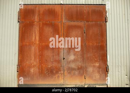 Rostige Tore. Große Stahltore. Rostetes Metall. Details zum Produktionsbereich. Stockfoto