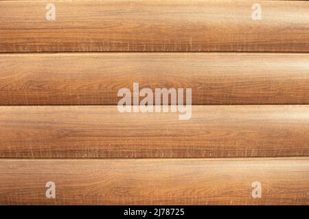 Schirm aus Holz. Holzhintergrund. Licht auf der Oberfläche. Braune Verkleidung aus Holz imitierender Plastik. Stockfoto