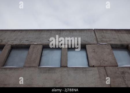 Verlassene Gebäude. Die Fenster sind mit Stahlblech dicht verschlossen. Verschlossenes Gebäude. Unvollendetes Haus in Russland. Stockfoto